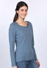Blau und grau gestreiftes Langarm-T-Shirt mit runder, gewellter Halslinie, aus weichem Stoff, getragen mit blauen Jeans.