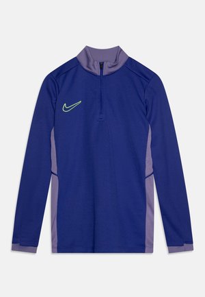 T-shirt de sport à manches longues avec un corps violet, des accents gris et un col zippé. Présente un logo swoosh Nike en vert vif.