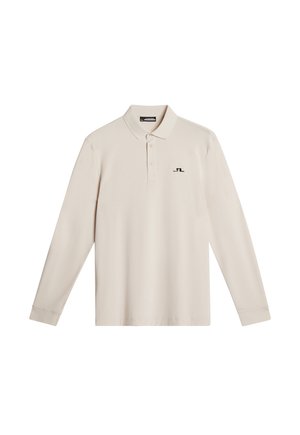Polo shirt beige chiaro a maniche lunghe con colletto classico, pattina con tre bottoni e un piccolo logo nero sul lato sinistro del petto. Tessuto dalla consistenza liscia.