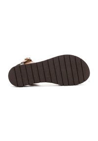 Suola di gomma marrone con scanalature verticali e un leggero rialzo del tacco. Presenta una forma curvata e un attacco a cinturino con fibbia sulla parte superiore.