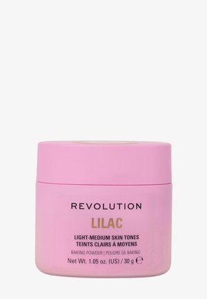 Conteneur rose de poudre à lever étiqueté "Révolution Lilas" pour les teints clairs à moyens. Contient 30 g. Texture lisse, forme circulaire.
