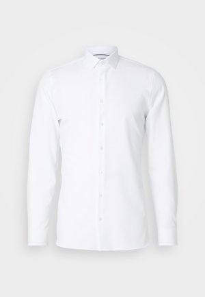 Hvit langermet skjorte laget av glatt stoff, med pointed krage og knappestolpe foran. Ingen mønstre eller dekorasjoner.