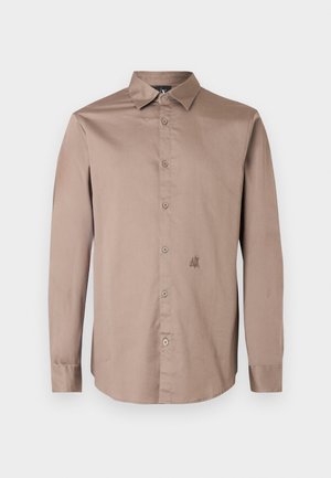 Ανοιχτό καφέ πουκάμισο με μακριά μανίκια και κουμπιά, κατασκευασμένο από απαλό ύφασμα, με μυτερό γιακά και διακριτική κεντητή λογότυπο στο στήθος.