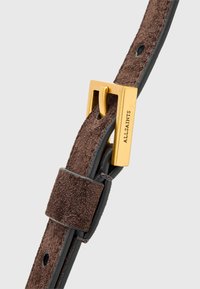 Bruine suède riem met gouden metalen gesp, met een rechthoekige vorm en textuur. Inclusief een lederen accent en meerdere gaten.