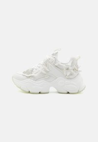 Witte sneakers met een dikke zool, voorzien van bloemvormige accenten, gestructureerde materialen en een vetersluiting met logo-details.