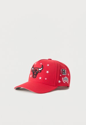 Casquette de baseball rouge avec logo de taureau noir, motifs d'étoiles blanches et écussons brodés sur le côté comprenant "CHI" et un emblème de couronne de laurier.
