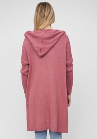 Lang, hette cardigan i myk rosa strikk, med en avslappet passform og ribbede mansjetter. Lengden når midt på låret, med en strukturert finish.
