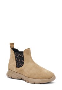 Botas de tobillo de ante color marrón claro con paneles laterales elásticos que presentan un patrón negro. Punta redonda y suela de goma ligera. Sencillo tirador en la parte trasera.