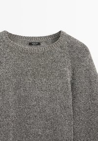 Pull gris en maille à manches longues avec un col rond et une étiquette Massimo Dutti cousue à l'intérieur du col.