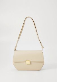 Beige leather crossbody bag with a structured shape, gold hardware clasp, and a smooth texture. Adjustable strap for versatile use.