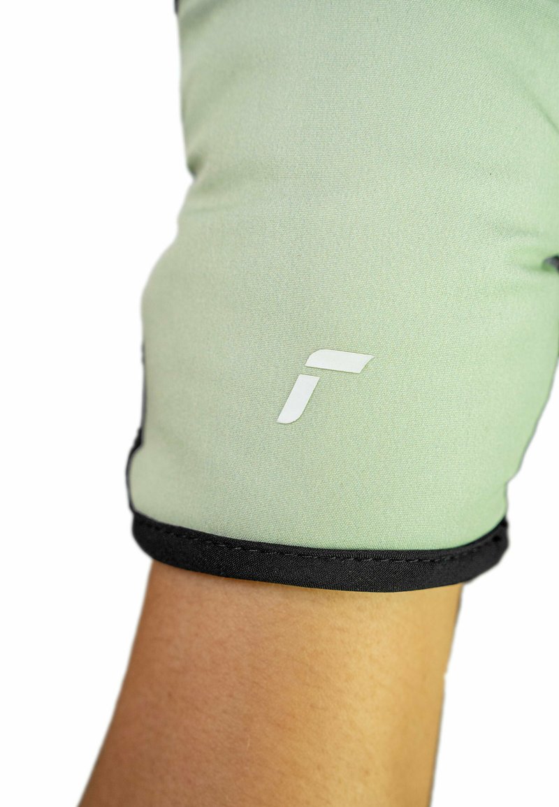 Helle grüne Stoff-Armschlaufe mit schwarzem Besatz. Verfügt über ein weißes Logo im oberen Bereich. Glatte Textur, enger Sitz.