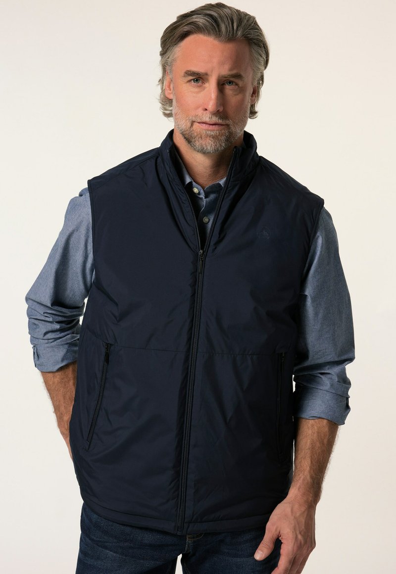 Marinblå ärmlös väst gjord av ett slätt och lätt material. Har en hög krage, dragkedja fram och två sidofickor.