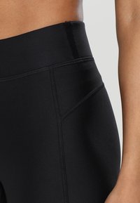 Höga svarta leggings med en slät, stretchig tyg och framträdande sömmar samt en snygg, åtsittande design.