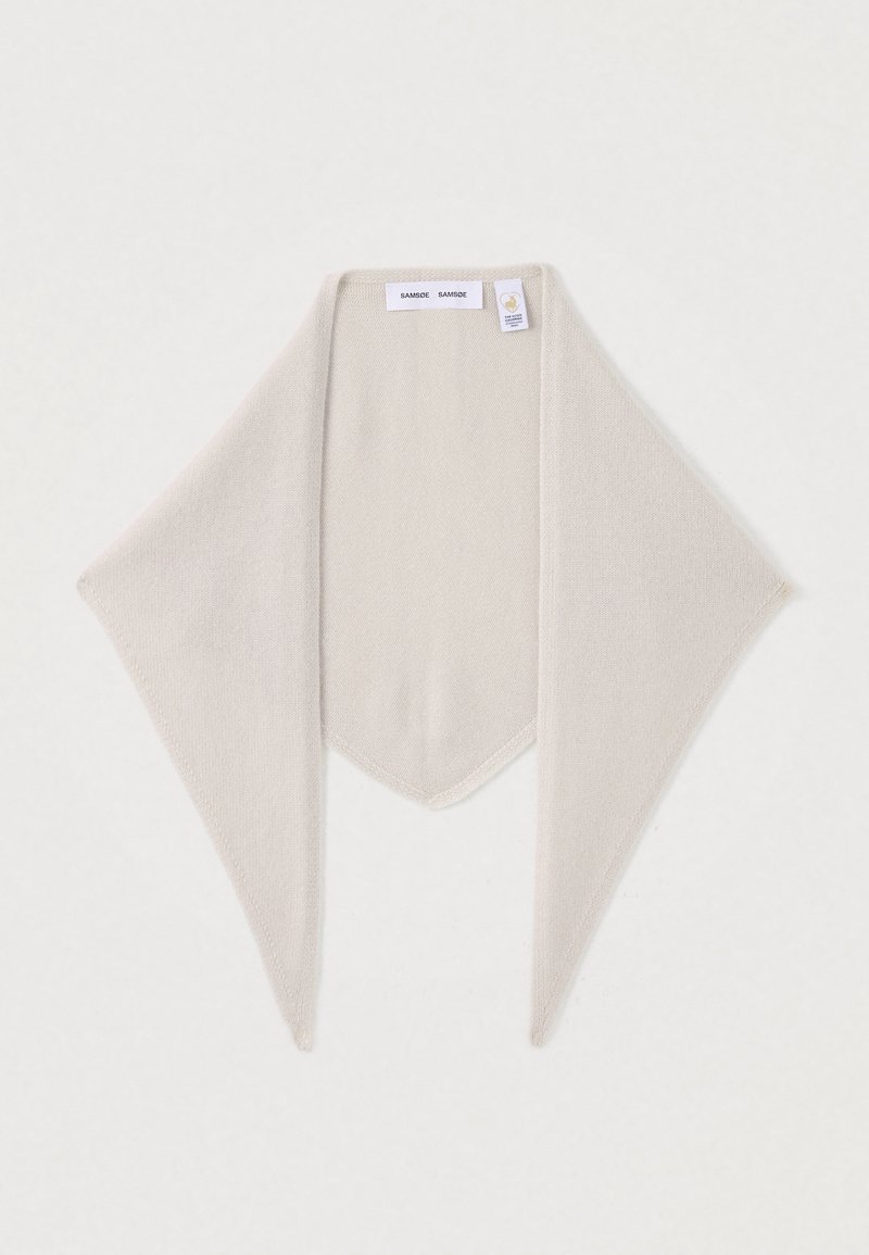 Écharpe triangulaire beige en tricot avec extrémités pointues, comportant une étiquette de marque et un tag de certification près du bord supérieur.