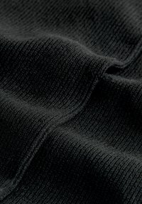 Schwarzer gerippter Stoff mit einer weichen Textur, der vertikale Linien aufweist, die einen leichten Glanz erzeugen. Das Material wirkt leicht elastisch und glatt.