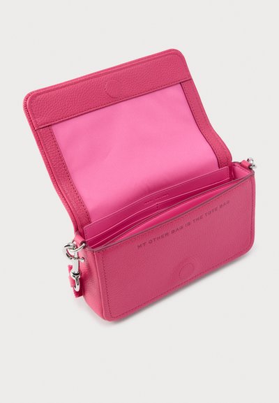 Vaaleanpunainen nahkainen olkalaukku, jossa on teksturoitu pinta, vetskari suljenta, avoin sisäosa ja teksti "MY OTHER BAG IS THE TOTE BAG" sisäpuolella.