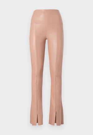 Huggende, hoge taille, blush-kleurige broek gemaakt van een soepele, rekbare stof met zijsplitten aan de zoom. Naaddetails aanwezig.