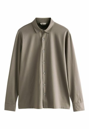 Khaki pitkähihaainen pusero, jossa on klassinen kaulus, viisi nappia edessä ja sileä kangas. Hihat ulottuvat ranteeseen.