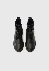 Sorte læderstøvler med en struktureret finish, rundet tå, snøredesign og lynlås i siden. Tykt gummisål for ekstra holdbarhed.