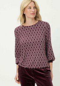Bordeauxrotes Oberteil mit Dreiviertelärmeln und einem geometrischen sechseckigen Muster in Pink. Weicher Stoff mit lockerem Sitz.