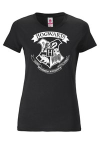 Musta puuvillapaita, jossa on valkoinen Hogwartsin vaakuna kuvasto, joka sisältää kilven, eläinsymboleita (leijona, käärme, kotka) sekä tekstilakanan.