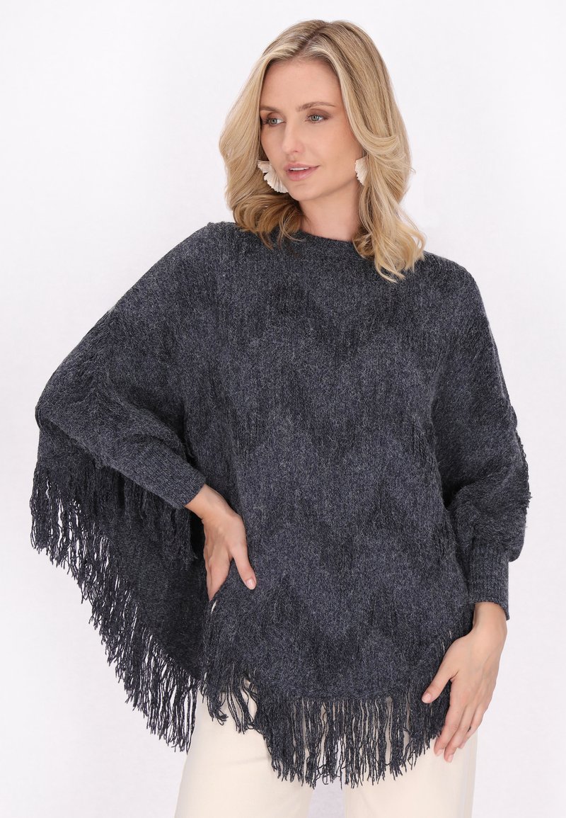 Poncho grigio scuro con frange e un motivo lavorato a maglia testurizzato, caratterizzato da un design aperto e maniche lunghe, mostrato su uno sfondo chiaro.
