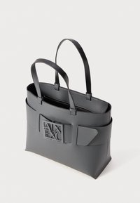 Borsa a spalla grigia realizzata in materiale sintetico testurizzato, con doppio manico superiore, caratterizzata da un logo prominente e numerose tasche esterne.