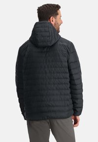Zwarte geïsoleerde pufferjas met horizontale stiksels en een capuchon, met een logo op de schouder. Glad, duurzaam materiaal.