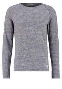 Grå stickad tröja med långa ärmar, rund halslinning och en texturerad yta. Litet märkesetikett på den nedre sidan.