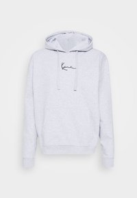 Jasnoszara bluza z kapturem z przodu z kieszenią kangurką, sznurkiem regulującym kaptur oraz czarnym logo na piersi. Miękki materiał i luźny krój.