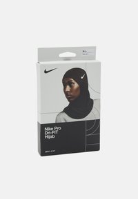 De verpakking van de Nike Pro Dri-FIT Hijab toont een donkere hijab op een model, met een zwart-wit ontwerp en het Nike-logo duidelijk zichtbaar.