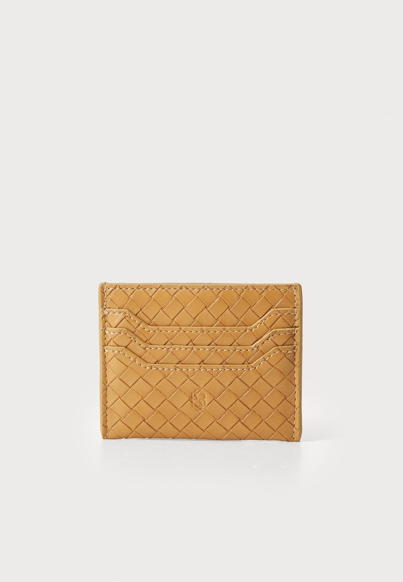Leather cardholder in golden tan, featuring a woven texture, multiple card slots, and embossed logo detail on the front.