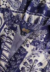 Navy- und weißes Blumenkleid mit kragenförmigem Ausschnitt und lebhaften Textilien, das mit kunstvollen Designs und einer weichen Textur begeistert.