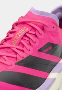 Nærbillede af en lyserød Adidas Adizero løbesko med sorte striber og lilla inderfor, der viser snørebånd og detaljerne i skoens tekstur.