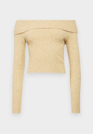 Yksi olkaimia vapaana oleva pitkähihainen paita, vaaleanbeigeä neulottua kangasta, jossa on ribbauskaulus. Lyhyt malli pehmeällä tekstuurilla.