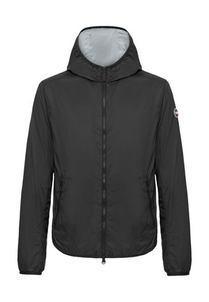 Musta kevyt hupullinen takki, jossa on täysi etuvetoketju ja vetoketjulliset sivutaskut, sekä pieni pyöreä logo vasemmassa hihassa.