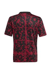 Camisa de manga corta con una tela negra que presenta un patrón floral texturizado en rojo, incorporando enredaderas entrelazadas y elementos geométricos.