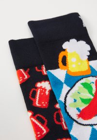 Colorful socks featuring beer mugs and a blue and white diamond pattern. Made from knitted fabric with a smooth texture.