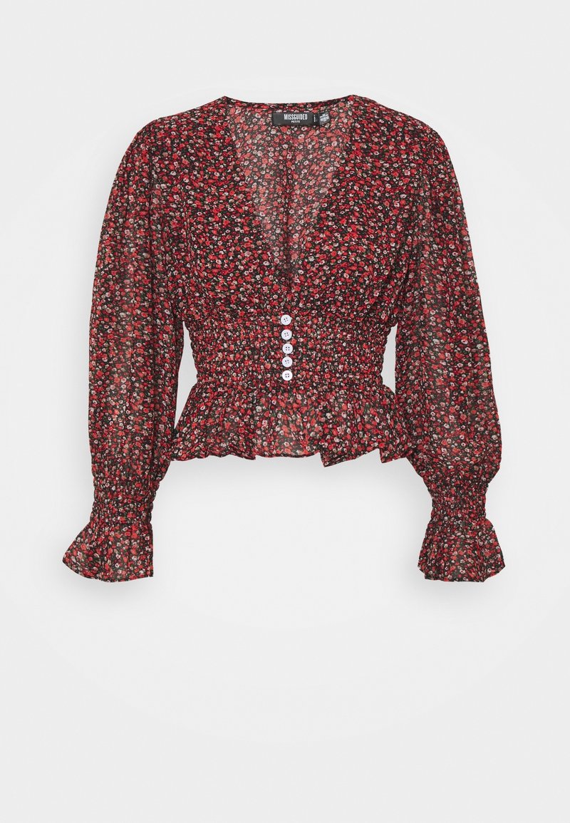 Blouse florale rouge avec de longues manches bouffantes. Présente un décolleté en V, une taille froncée et cinq boutons blancs sur le devant. Tissu léger.