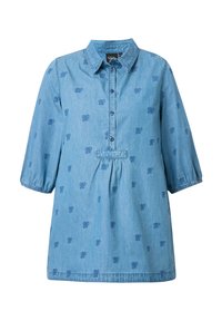 Camicia in denim di colore azzurro chiaro, con colletto, apertura anteriore con bottoni e maniche a 3/4. Presenta un sottile motivo a fiocchi e una vita arricciata.