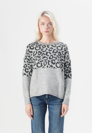 Pull en tricot gris avec un motif léopard sur la partie supérieure, manches longues et coupe décontractée, associé à un jean bleu.