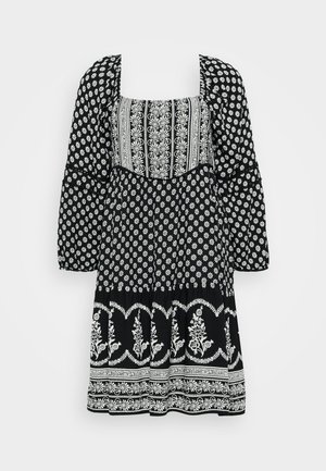 Un vestido negro con patrones florales blancos, un escote cuadrado, mangas abullonadas y una falda acampanada con acentos decorativos.