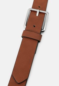 Bruine leren riem met een gestructureerde afwerking, voorzien van een zilverkleurige rechthoekige gesp en verschillende gaatjes voor verstelling, taps toelopend aan één uiteinde.