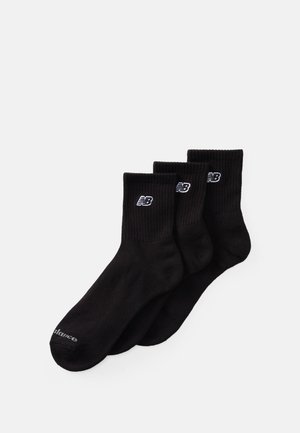Chaussettes en coton noir dans un pack de trois. Texture côtelée avec un revers replié. Présente un logo brodé blanc sur le côté et un orteil renforcé.