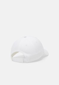Gorra de béisbol blanca con visera curvada, textura de tela, diseño de seis paneles y correa adjustable en la parte posterior. Sin logotipos ni patrones visibles.