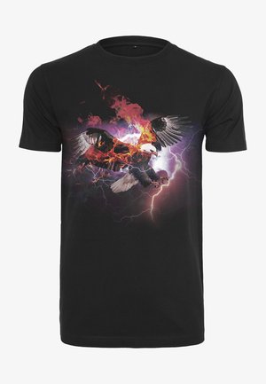T-shirt en coton noir avec un graphisme coloré représentant un aigle entouré de flammes, d'éclairs et de nuages orageux en arrière-plan. Manches courtes.