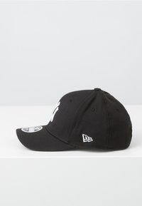 Gorra de béisbol negra con visera curva, logotipo blanco en el frente y detalle de marca en el lateral. La tela es suave y tiene una forma estructurada.