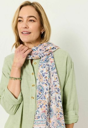 Lightweight paisley-patterned scarf in soft fabric, featuring blue, orange, and green accents, wrapped around a person’s neck, complemented by a green shirt.