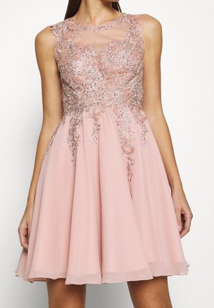 Różowa sukienka z dopasowanym gorsetem i rozkloszowanym dołem. Posiada misterną koronkę z koralików i kwiatowe hafty, przezroczystą siateczkę przy dekolcie oraz teksturowane wykończenie.