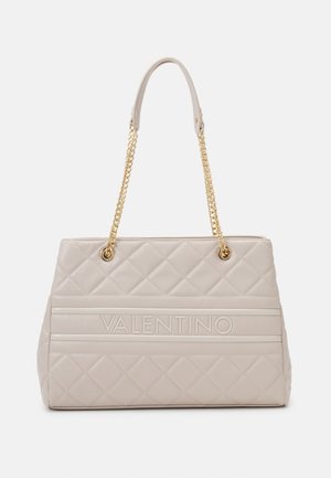 Sac à main matelassé beige avec anses en chaîne dorée et logo Valentino embossé sur le panneau central avant.